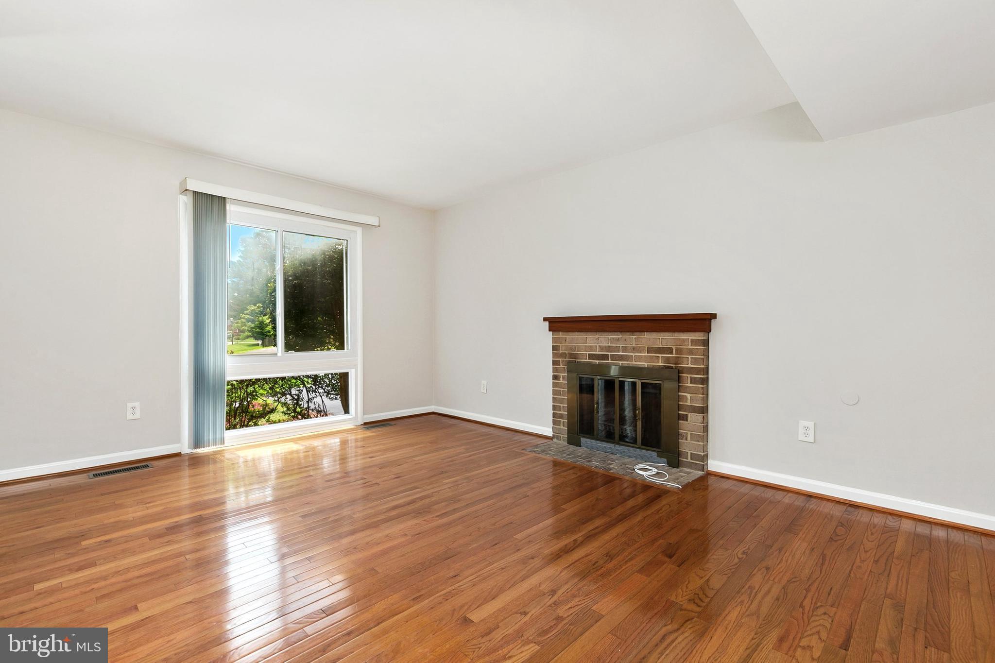 11501 Piney Lodge Road North Potomac, MD 20878 - Photo 7 of 64 an empty room with wooden floor and fireplace