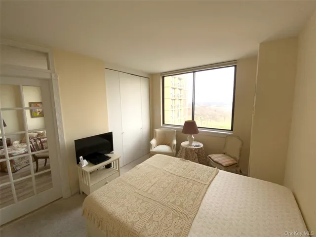 a bedroom with a bed and a television