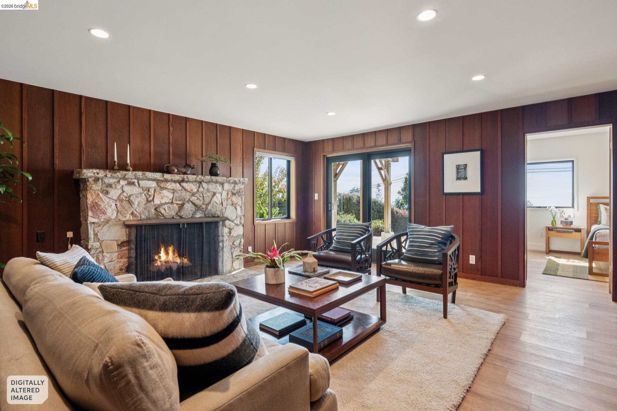 38 Highgate Road Kensington, CA 94707 - Photo 40 of 78 Stone-clad fireplace, wood-paneled walls, recessed lighting, wood-finish flooring, and double-paned sliding doors