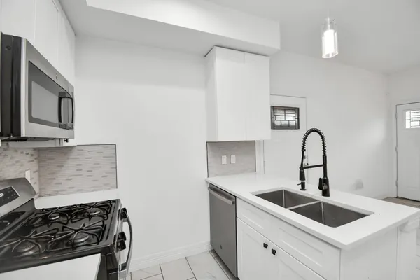 a kitchen with sink a stove and cabinets