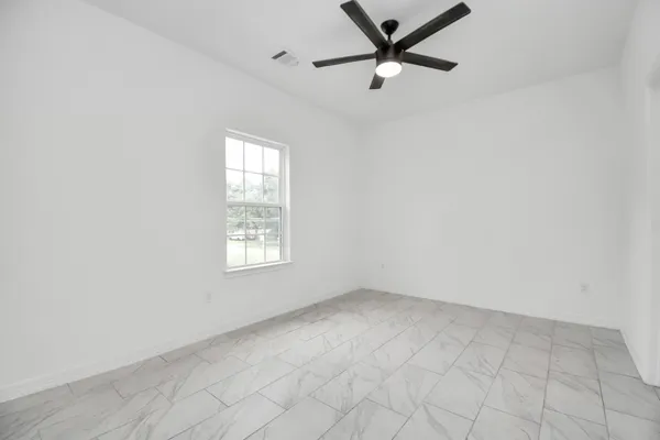 an empty room with a window and a fan