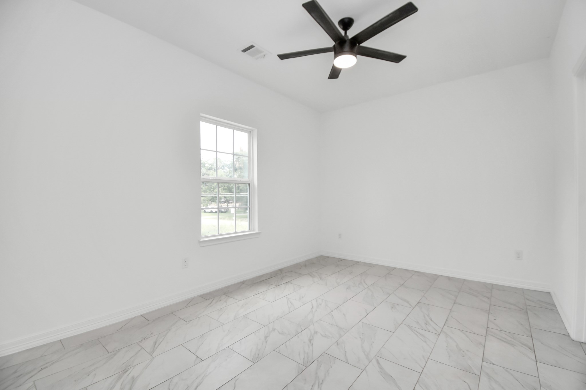 9003 Prairie View Drive, Unit B Houston, TX 77088 - Photo 13 of 20 an empty room with a window and a fan