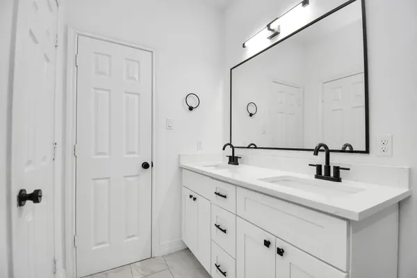 a bathroom with double sink and a mirror
