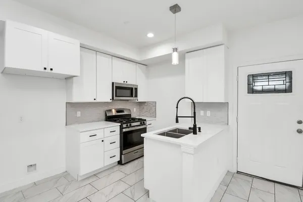 a kitchen with white cabinets stainless steel appliances and sink