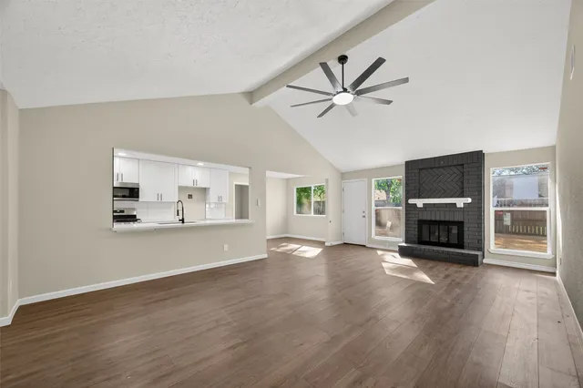 a view of an empty room with a fireplace and a window
