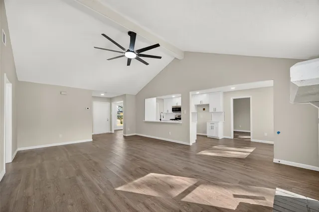 a view of a livingroom with wooden floor and a ceiling fan