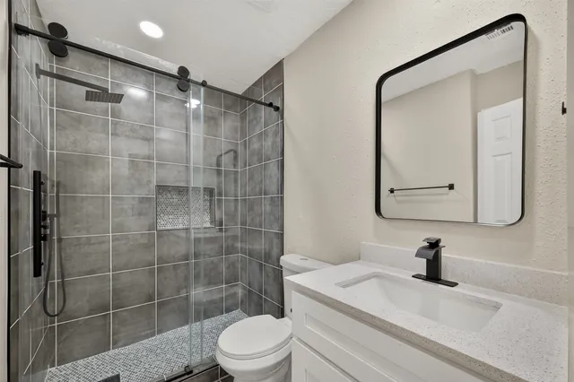 a bathroom with a shower a toilet and sink