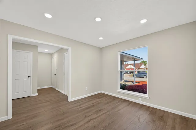a view of empty room with wooden floor