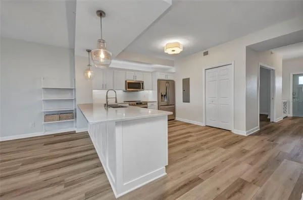 a view of kitchen with wooden floor and electronic appliances