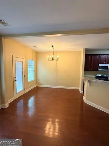 a view of a room with wooden floor and a window