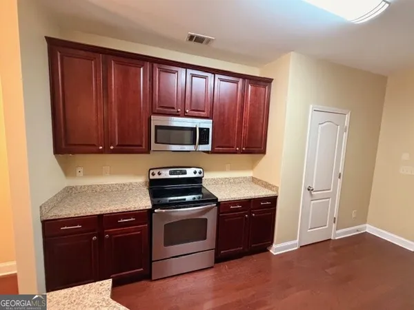 a kitchen with granite countertop wooden cabinets and stainless steel appliances