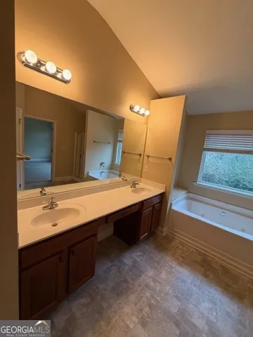 a bathroom with a sink a large mirror and a bathtub
