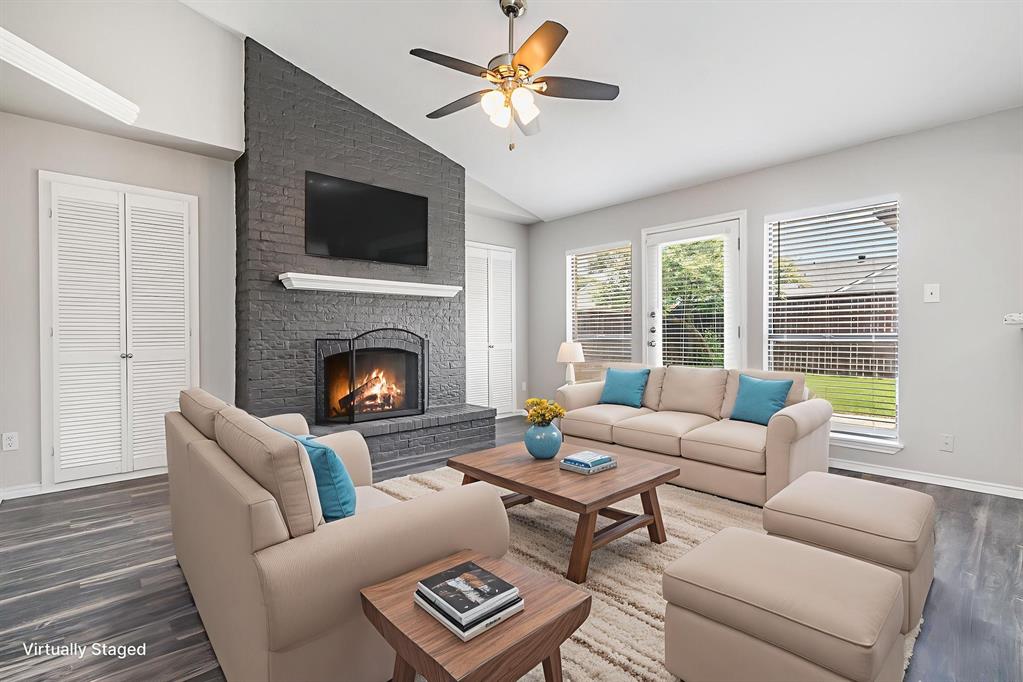 5633 Trego Street The Colony, TX 75056 - Photo 7 of 22 a living room with furniture a fireplace and a flat screen tv
