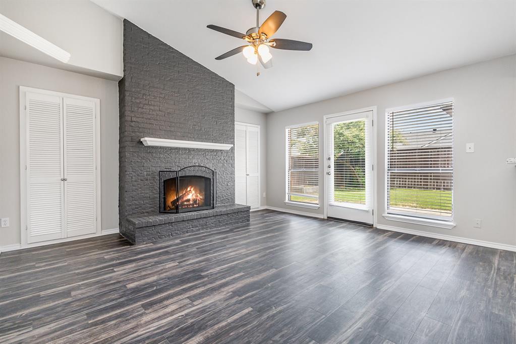 5633 Trego Street The Colony, TX 75056 - Photo 8 of 22 wooden floor fireplace and windows in an empty room