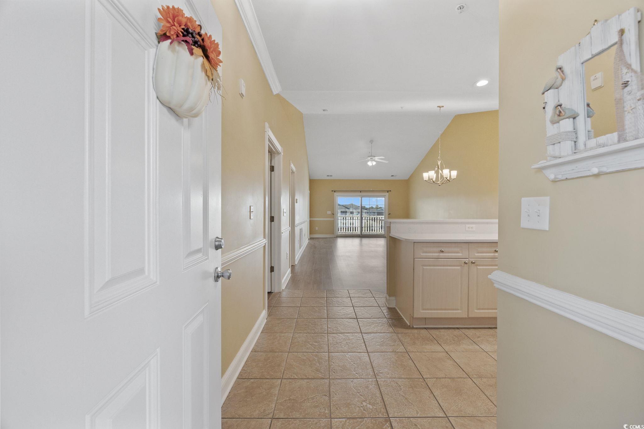 4847 Luster Leaf Circle, Unit 403 Myrtle Beach, SC 29577 - Photo 2 of 37 Corridor with vaulted ceiling, a chandelier, and light tile patterned floors