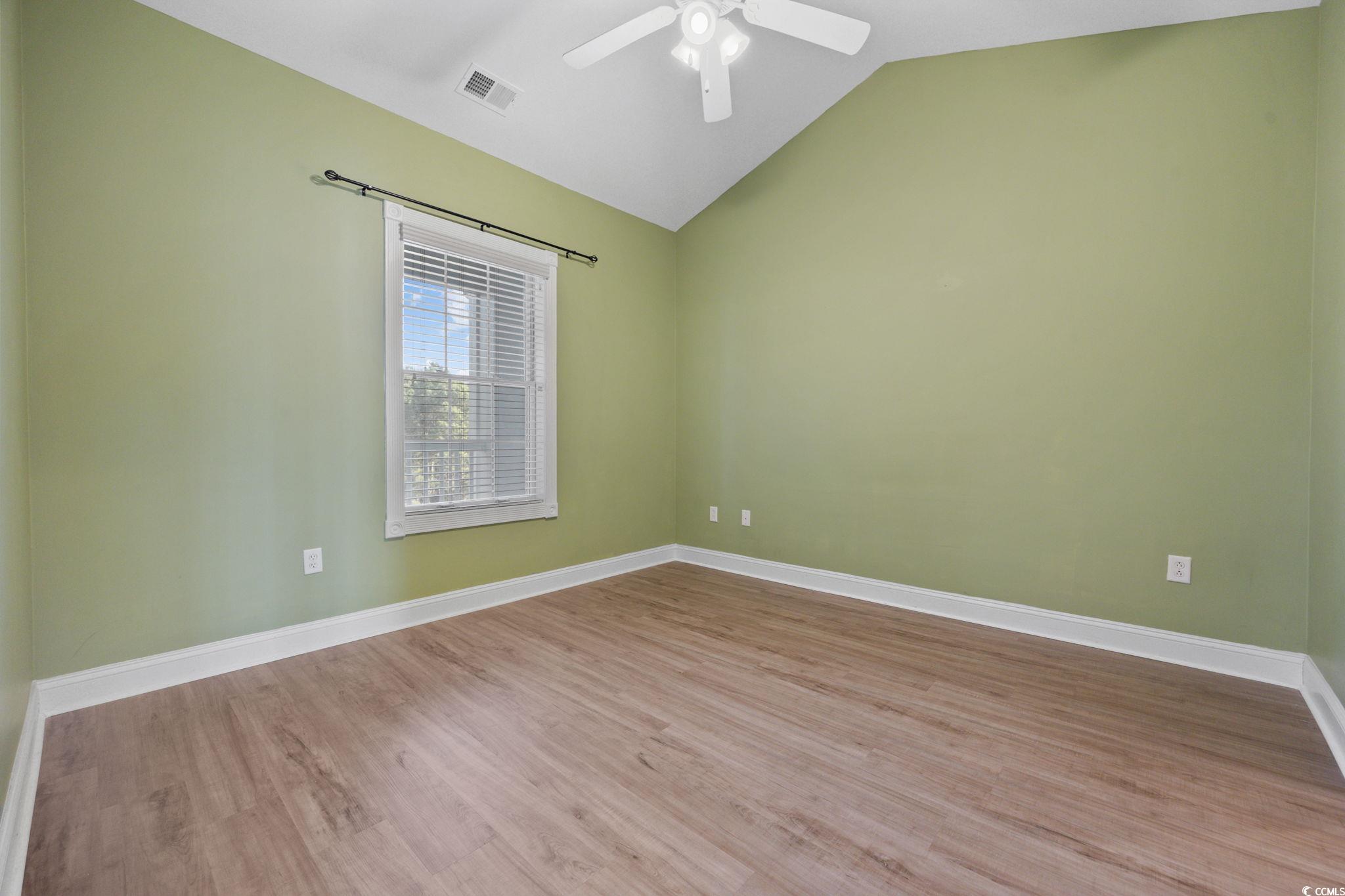 4847 Luster Leaf Circle, Unit 403 Myrtle Beach, SC 29577 - Photo 21 of 37 Empty room with vaulted ceiling and wood finished floors
