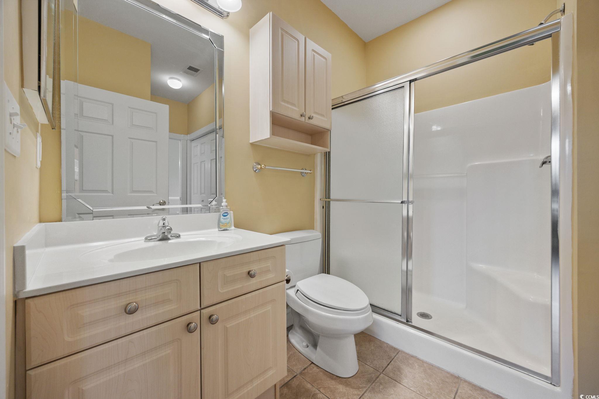 4847 Luster Leaf Circle, Unit 403 Myrtle Beach, SC 29577 - Photo 23 of 37 Full bathroom featuring a shower stall, vanity, and light tile patterned floors
