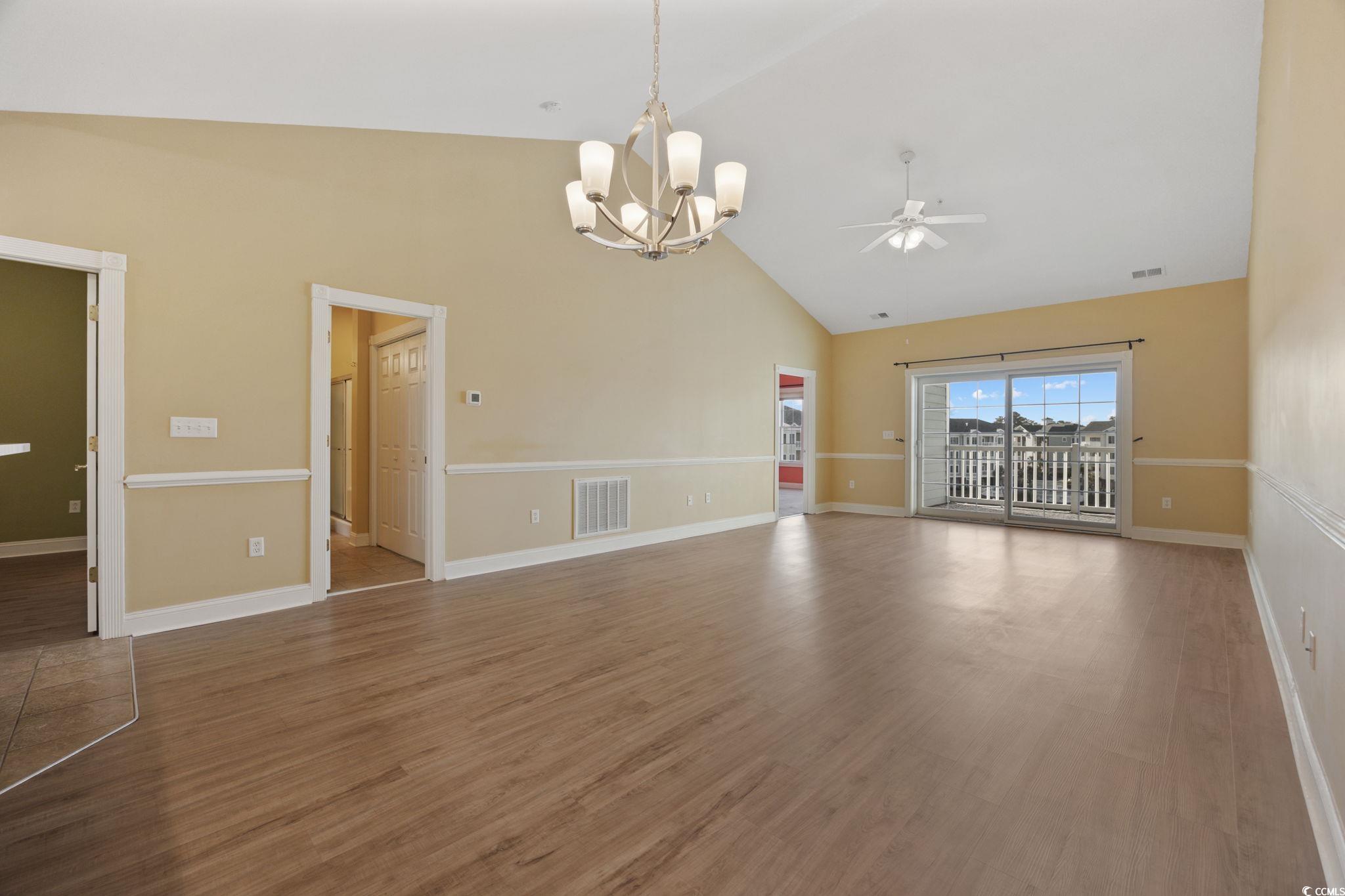 4847 Luster Leaf Circle, Unit 403 Myrtle Beach, SC 29577 - Photo 5 of 37 Unfurnished living room featuring a chandelier, high vaulted ceiling, wood finished floors, and a ceiling fan