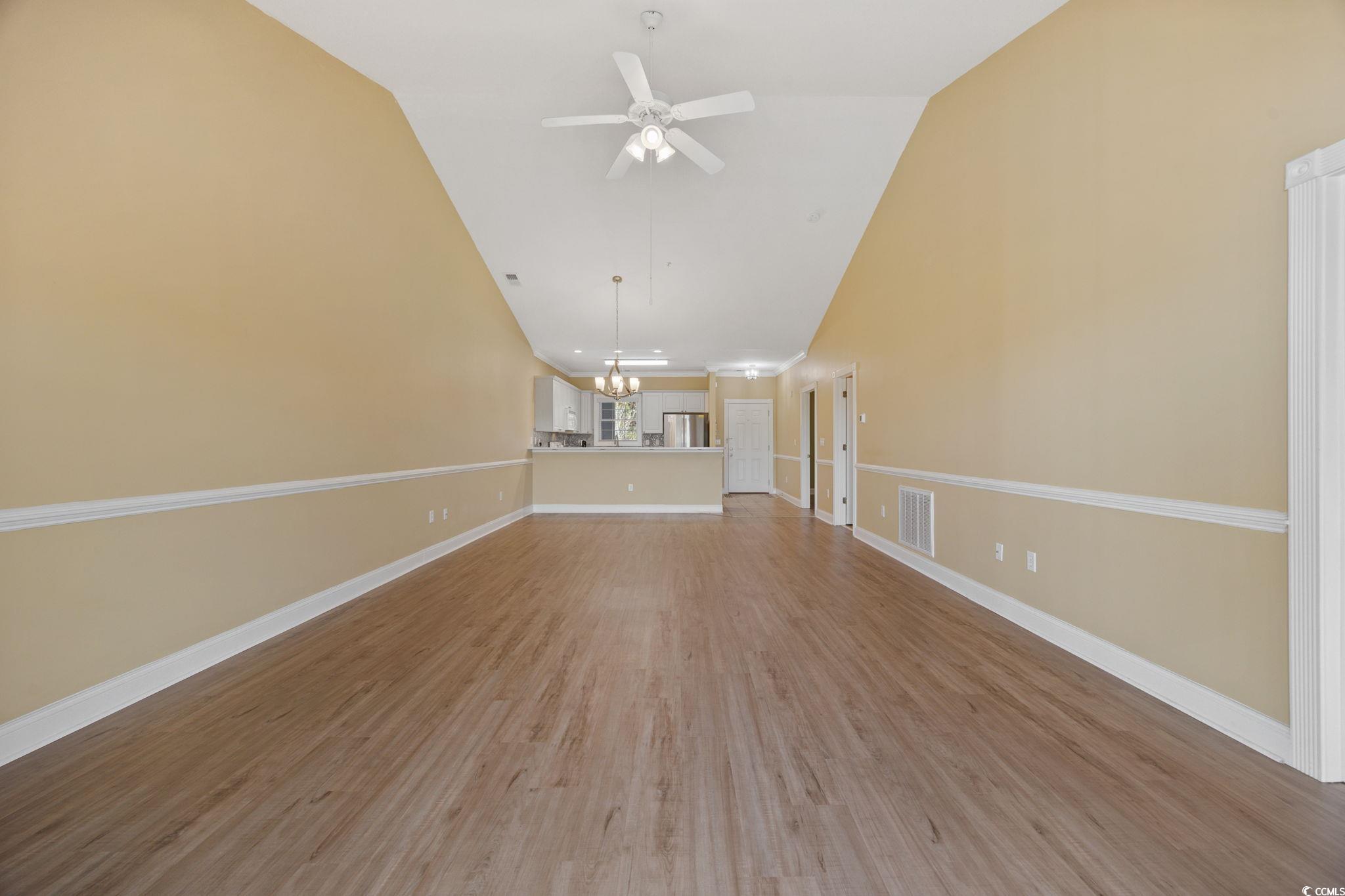 4847 Luster Leaf Circle, Unit 403 Myrtle Beach, SC 29577 - Photo 9 of 37 Unfurnished living room with wood finished floors, a chandelier, a ceiling fan, and high vaulted ceiling