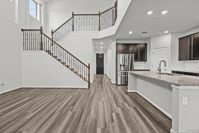 a view of a kitchen with wooden floor and electronic appliances