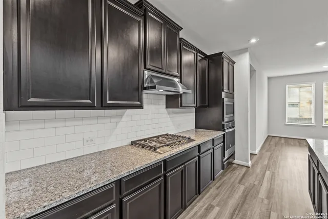 a kitchen with stainless steel appliances granite countertop a sink stove and refrigerator