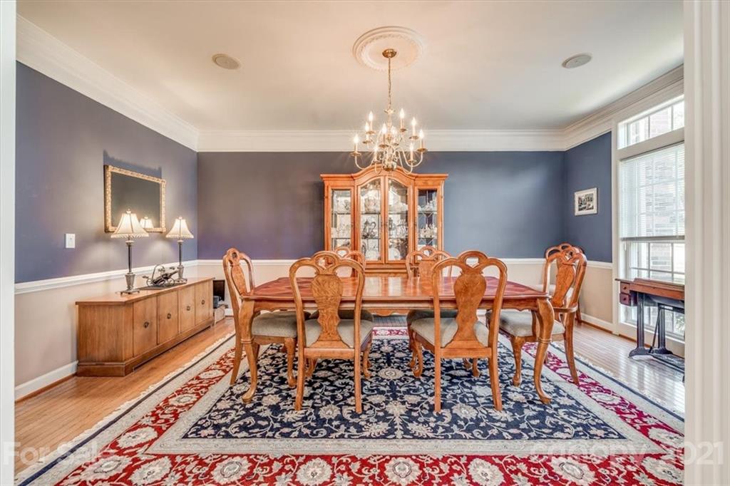 152 Melbourne Drive Fort Mill, SC 29708 - Photo 4 of 32 a dining room with wooden floor a chandelier a wooden table and chairs