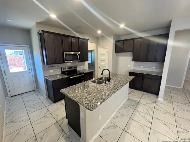 a kitchen with a sink a stove a microwave and refrigerator