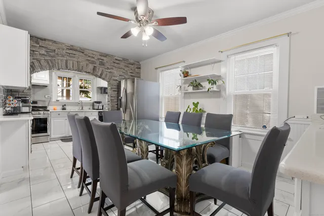 a view of a dining room with furniture and a chandelier fan