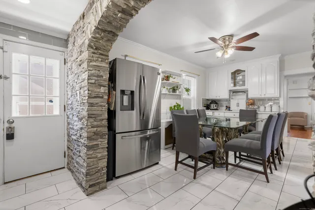 a dining room with furniture and a refrigerator