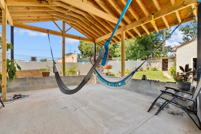 a view of a swimming pool with a patio and a backyard