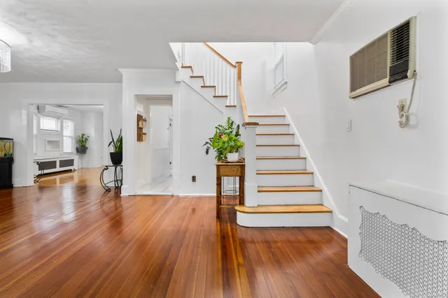 a view of a living room with wooden floor and stairs