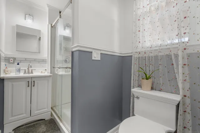 a bathroom with a granite countertop toilet sink and mirror