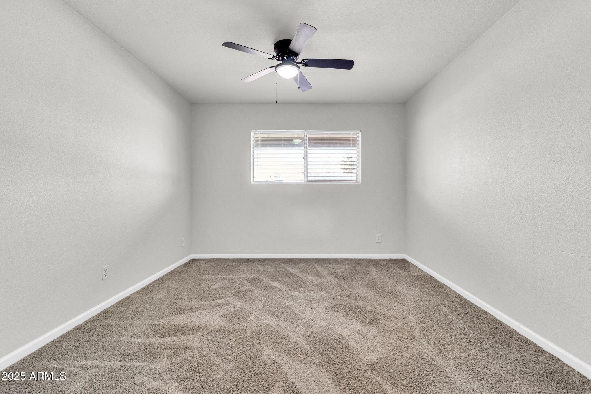 449 East Harmony Avenue Mesa, AZ 85204 - Photo 13 of 30 an empty room with a window and a ceiling fan
