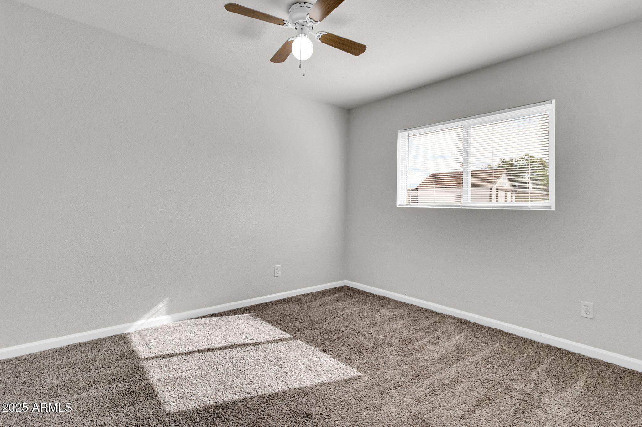 449 East Harmony Avenue Mesa, AZ 85204 - Photo 16 of 30 an empty room with a window and a fan