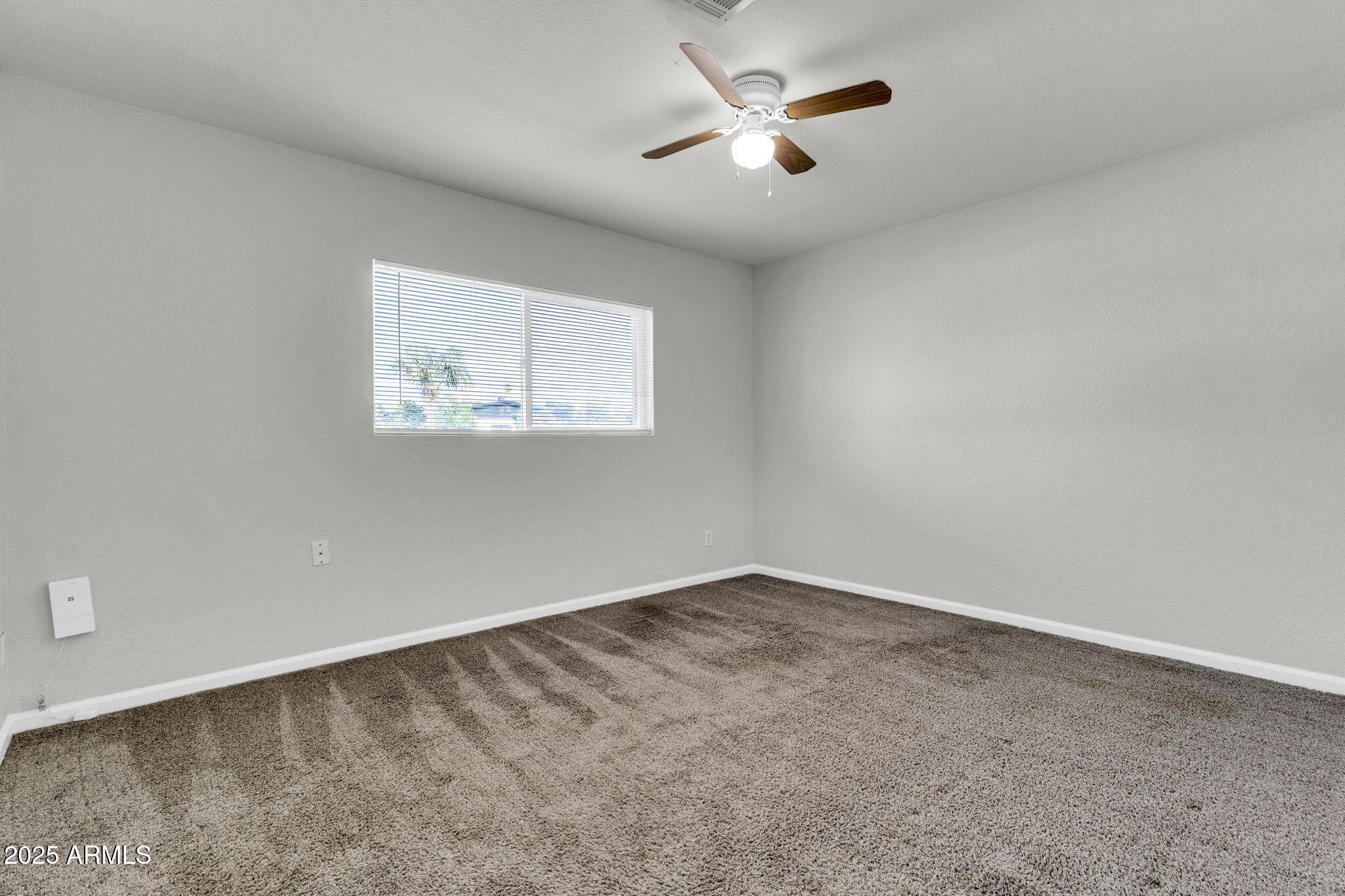 449 East Harmony Avenue Mesa, AZ 85204 - Photo 18 of 30 an empty room with a window and a fan