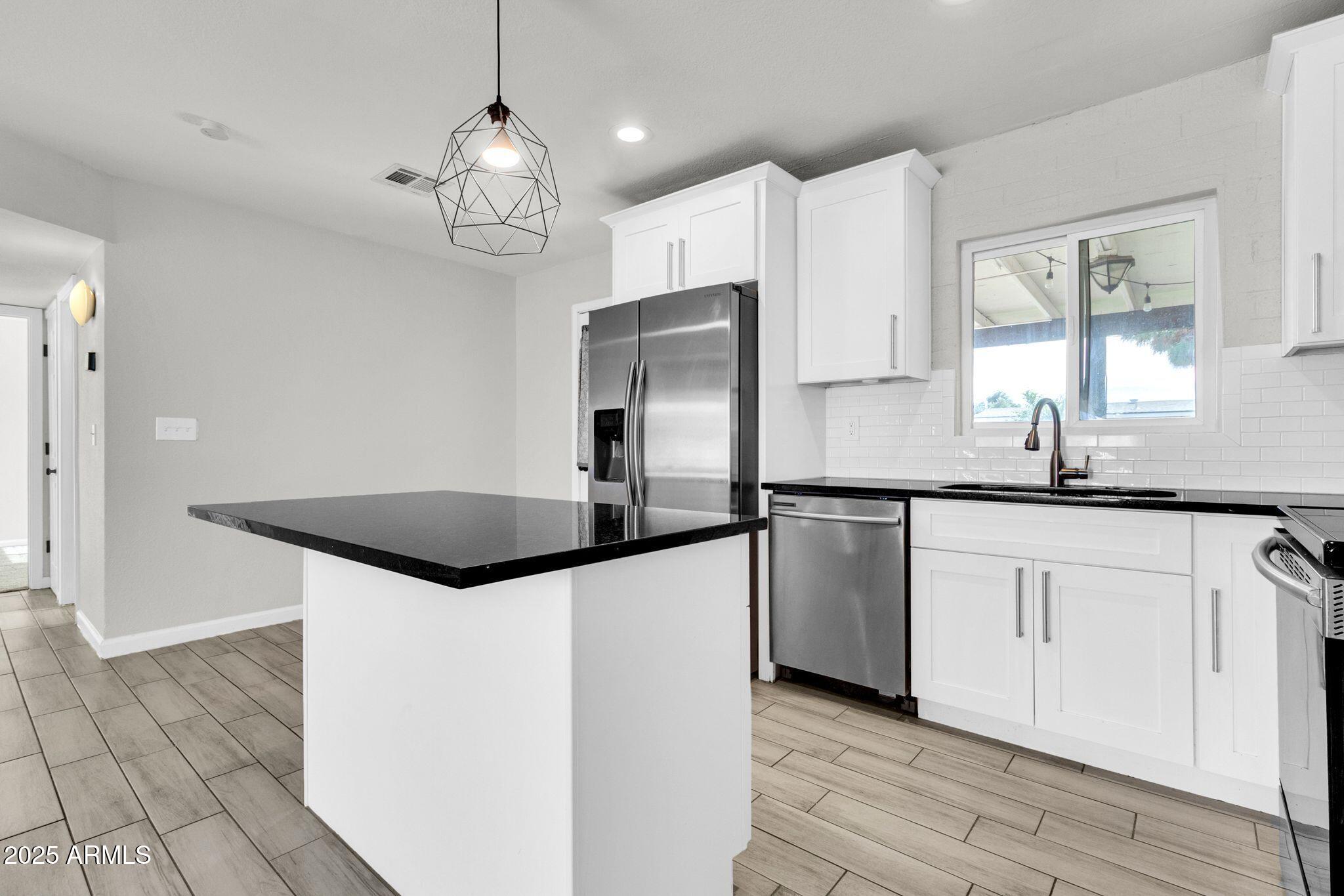 449 East Harmony Avenue Mesa, AZ 85204 - Photo 7 of 30 a kitchen with granite countertop a sink cabinets and stainless steel appliances