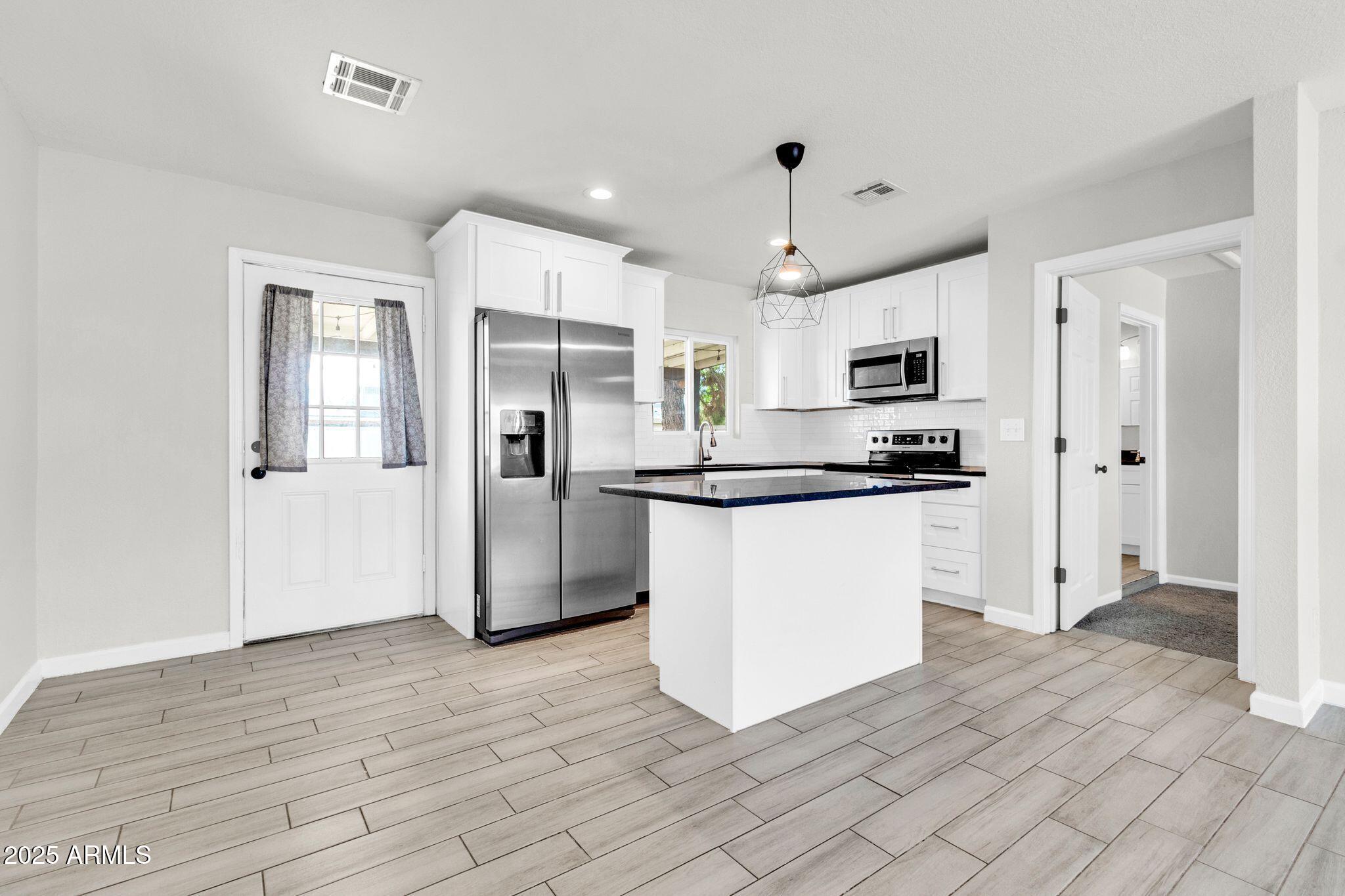 449 East Harmony Avenue Mesa, AZ 85204 - Photo 8 of 30 a kitchen with stainless steel appliances a refrigerator sink and microwave