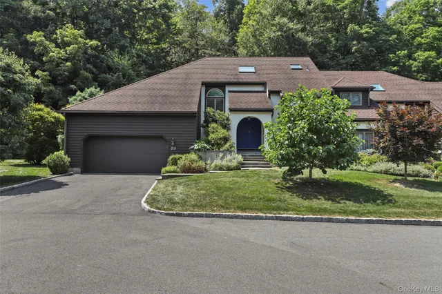 a front view of a house with a garden and yard