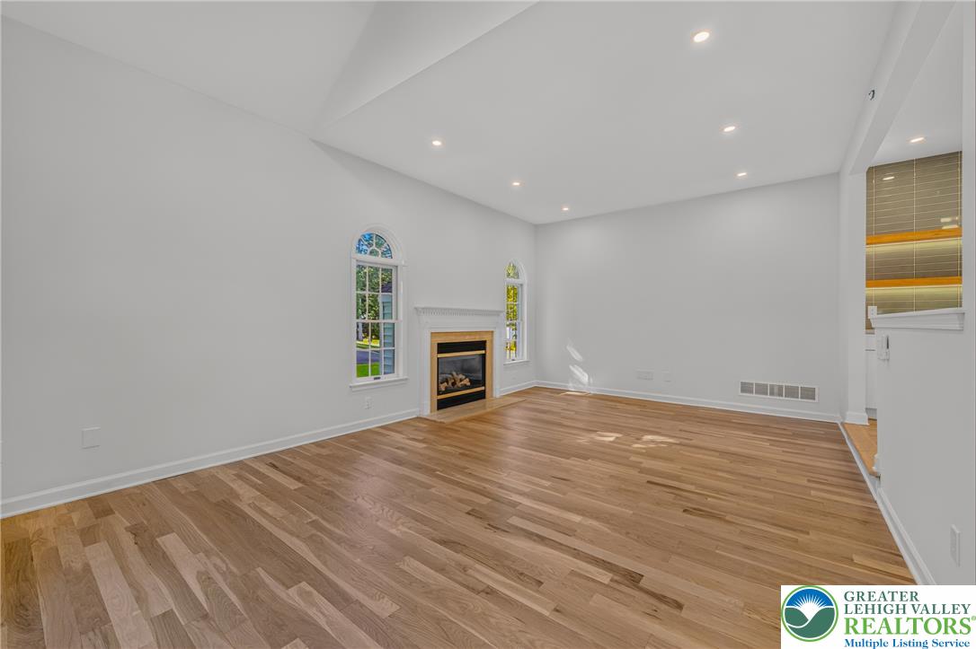 3130 Muirfield Road Center Valley, PA 18034 - Photo 14 of 63 Warm hardwood floors and a classic fireplace anchor this light-filled room with vaulted ceilings.