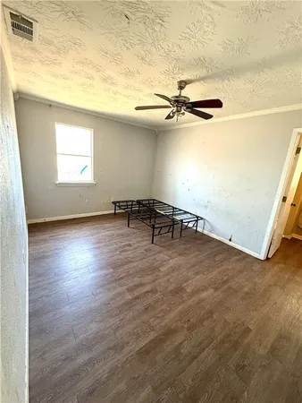 an empty room with windows and ceiling fan