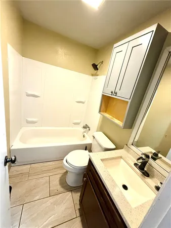 a bathroom with a sink mirror toilet and bathtub