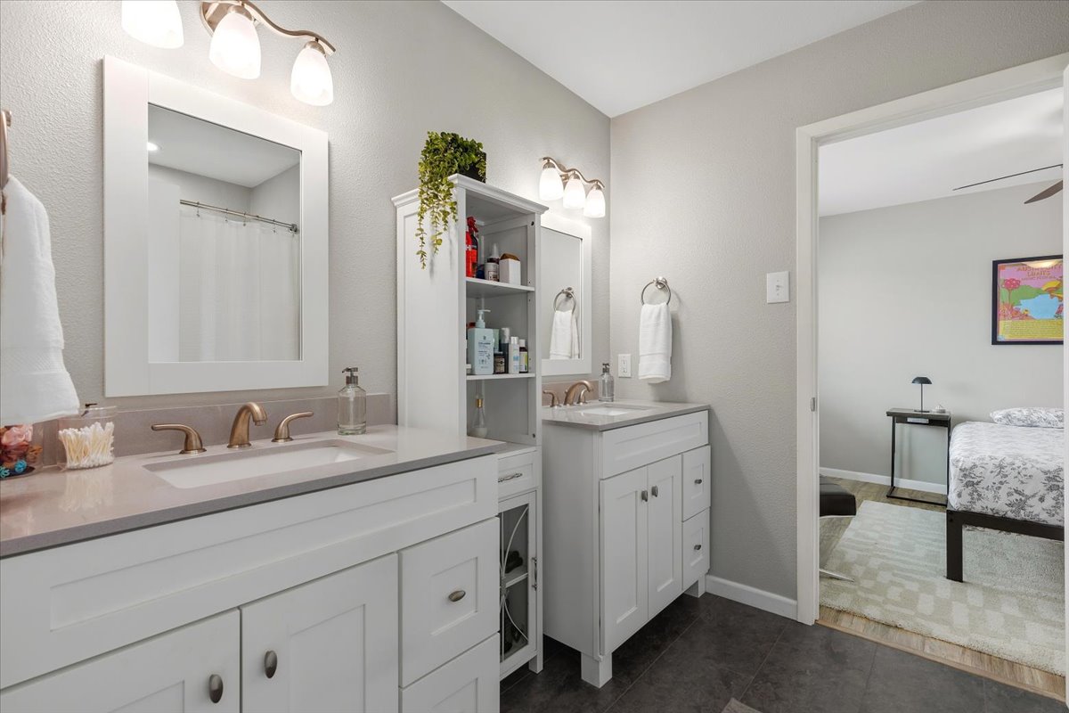208 Skyloop Drive Austin, TX 78745 - Photo 19 of 34 Updated bathroom with dual vanities, modern finishes, and functional shared layout.