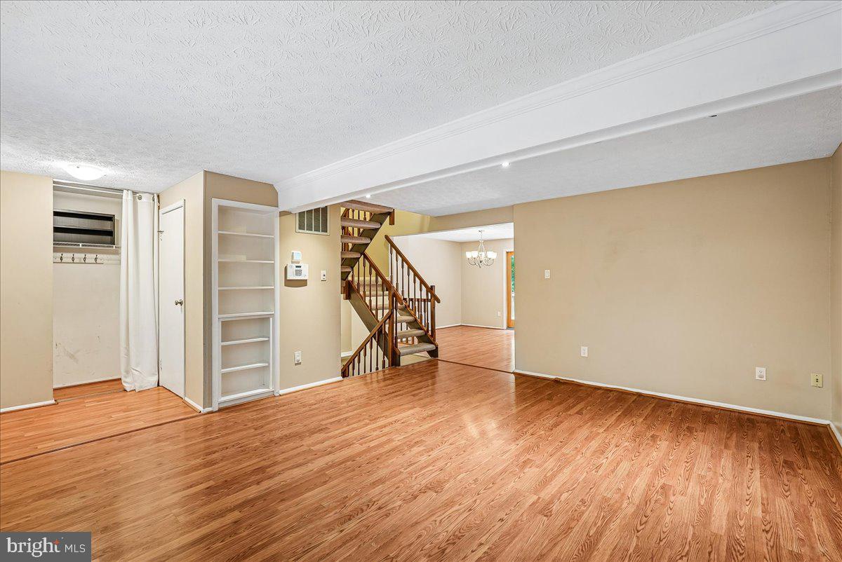 2331 Middle Creek Lane Reston, VA 20191 - Photo 12 of 78 a view of an empty room with wooden floor stairs and a way to kitchen