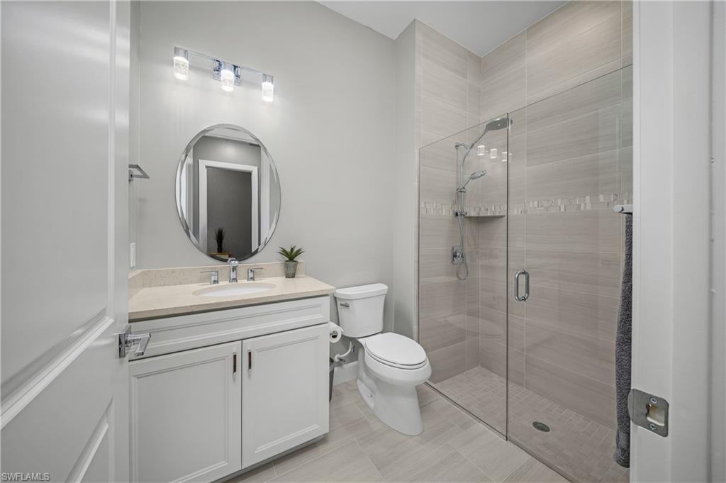 17574 Ashcomb Way Estero, FL 33928 - Photo 17 of 32 a bathroom with a toilet sink vanity granite and shower