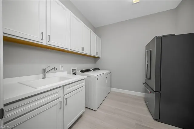 a utility room with cabinets washer and dryer