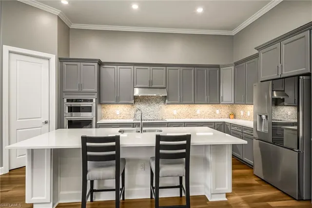 a kitchen with stainless steel appliances a stove a sink and a refrigerator