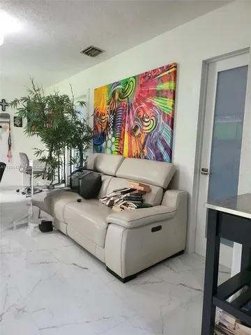 a living room with furniture and a painting on the wall