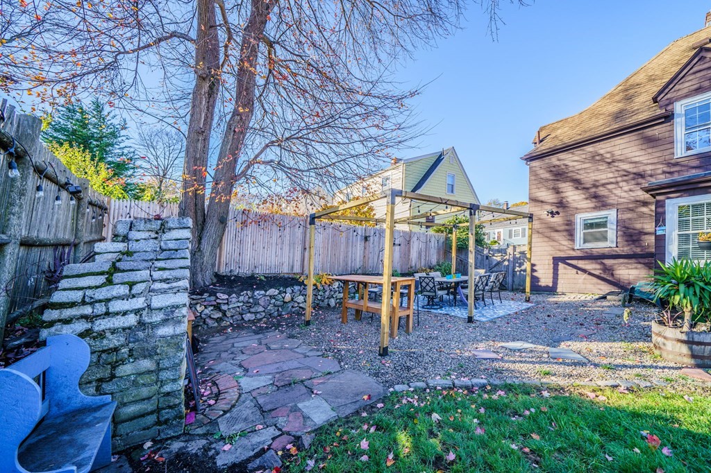 8 Samoset Road Dedham, MA 02026 - Photo 30 of 35 a view of a backyard with table and chairs potted plants and large tree