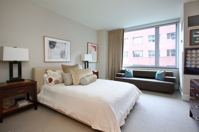 a bedroom with a bed couch and a window