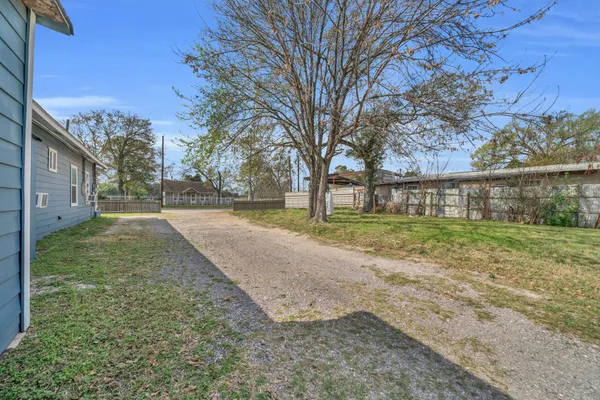 a view of a house with backyard and trees